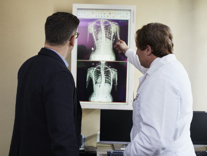 doctor pointing-x-ray-result-beside-man-wearing-black-suit-2182972